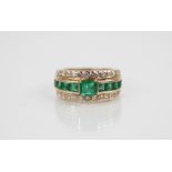 An emerald and diamond ring, the central octagonal step cut emerald measuring 5.25mm x 4.85mm,