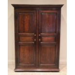 An 18th century oak hall cupboard, with a moulded cornice above a pair of panelled doors mounted