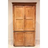 A Victorian pine freestanding corner cupboard, the moulded cornice above a pair of invert panelled