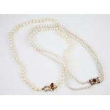 A cultured pearl necklace with a 9ct gold garnet set clasp, the single row of round cultured