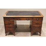 An Edwardian mahogany twin pedestal desk, the leather inset rectangular moulded top above an