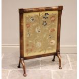 A mid-19th century mahogany framed, crewel work inset fire screen, depicting a floral spray,
