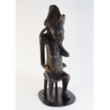 A Central African tribal fertility carving (possibly Congolese), modelled as a woman in tribal