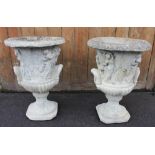 A pair of reconstituted campana garden urns, each of typical trumpet form, moulded in relief with