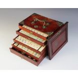 An early 20th bone and bamboo mahjong set, within a five drawer chest with brass swing handles, 16cm