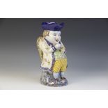 A French 'Rouen' Faience Toby Jug, 20th century, modelled as a gentleman taking snuff, painted and