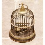 A brass bird cage, 20th century, of domed top form, with enclosed bird swing and perch above a