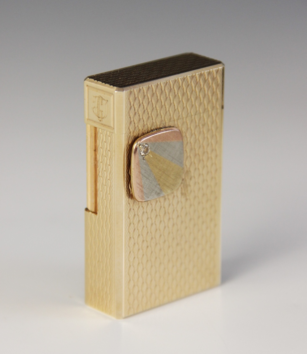 A Dupont diamond set gold plated lighter, of rectangular form with engine turned decoration, applied