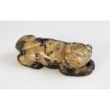 A Chinese jade carved dog, probably Western Han Dynasty, modelled in a recumbent position, 8cm wide