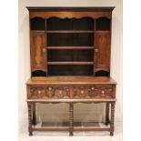 A 17th century style oak dresser, early 20th century, the high back with a moulded cornice above