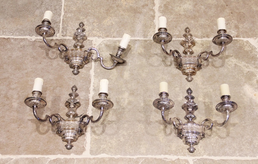 A set of four early 20th century silver plated twin branch wall light fittings, each with an urn