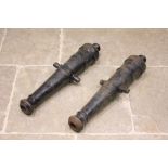 A pair of 19th style century cast iron canon barrels, each of typical ring turned tapering form,