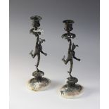 A pair of bronze figural candle holders, early 20th century, each cast as Hermes upon an