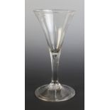 A conical wine glass, the waisted bowl on tear drop stem terminating in wide conical folded foot,