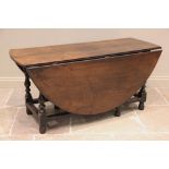 An early 18th century oak gateleg dining table, the oval table top raised upon baluster and block