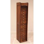 An early 20th century oak tambour front cabinet, of tall rectangular form with panelled sides, the