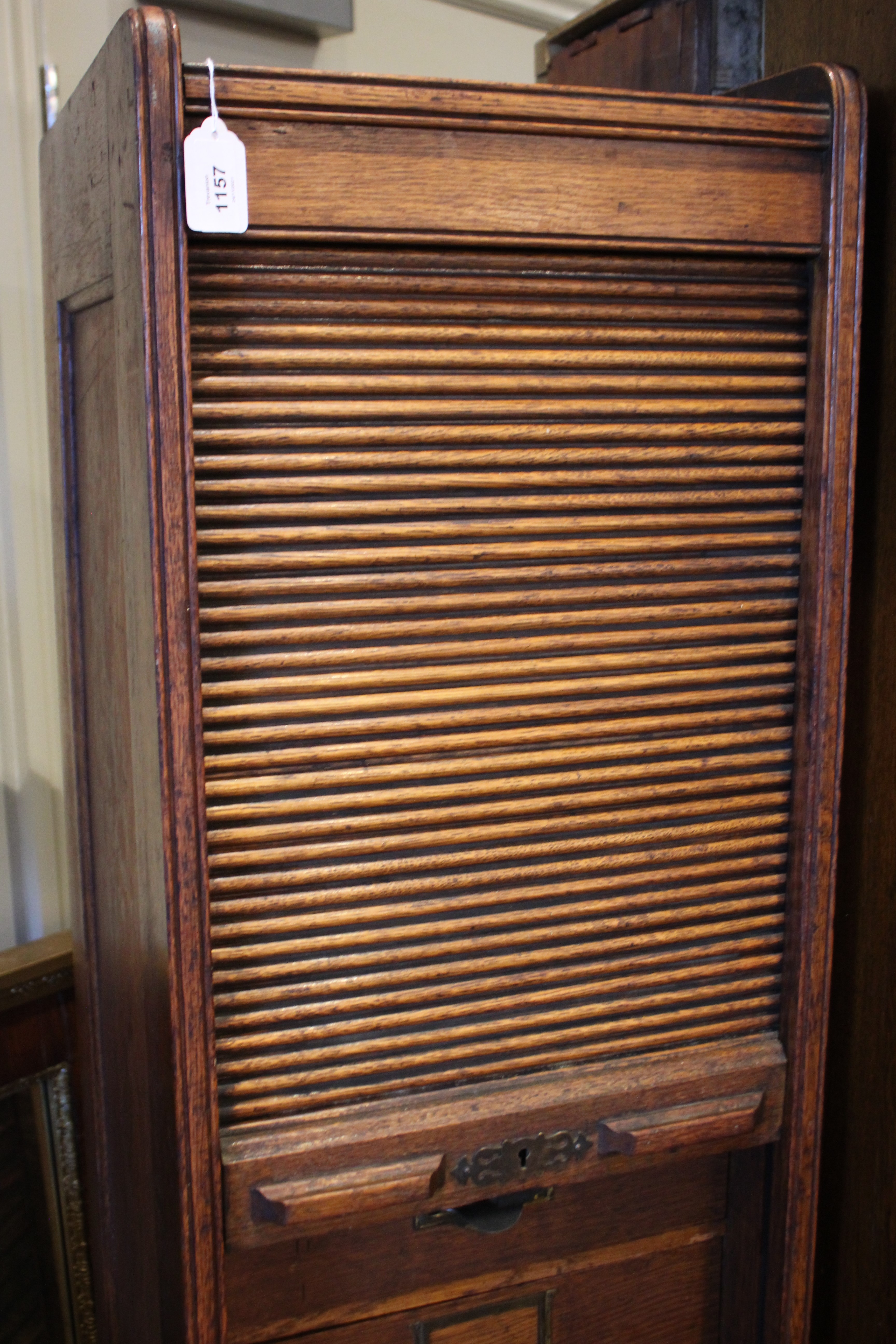 An early 20th century oak tambour front cabinet, of tall rectangular form with panelled sides, the - Bild 6 aus 8