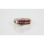 A ruby and diamond set 18ct gold ring, the buckle design ring set with square cut rubies and mixed