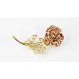 A diamond and ruby set 18ct gold floral brooch, designed as a rose, the petals set with round