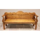 A 19th century French pine settle, with arch shaped back over a board seat upon legs of square