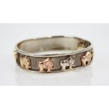 A 9ct gold hinged bangle, the white gold oval bangle with applied elephants in yellow, rose and