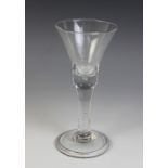 A bell bowl wine glass, the bowl with teared base on plain stem terminating in a wide conical folded