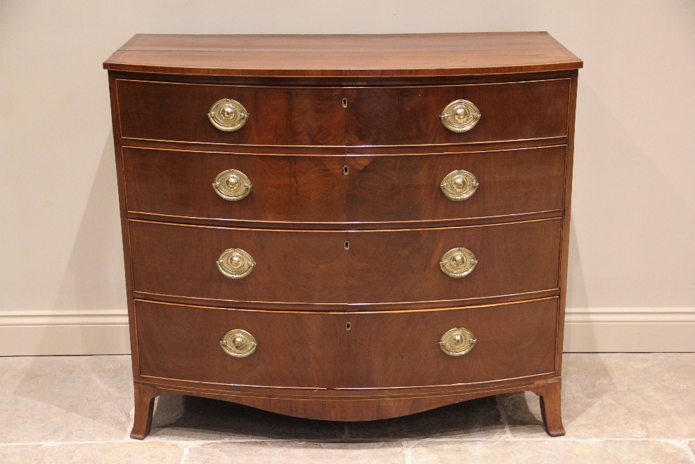 An early 19th century mahogany bow front chest of drawers, formed of two short of three long