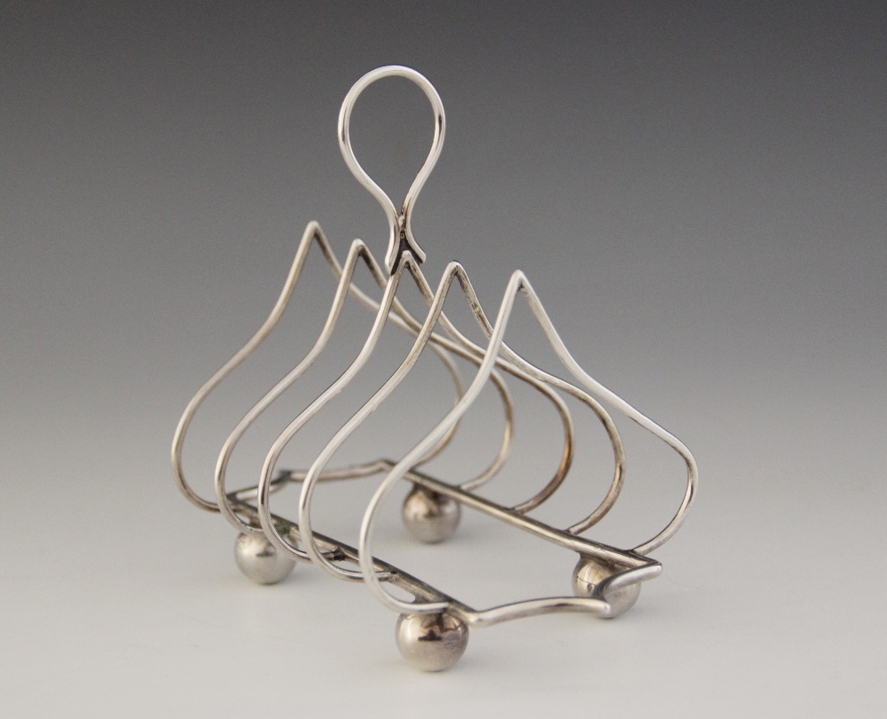 An Edwardian silver four division toast rack, Jones & Crompton, Chester 1906, ogee arches with