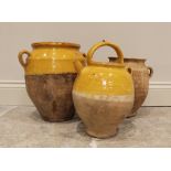 Three 19th century French glazed stoneware confit pots, to include a lidded example with loop handle