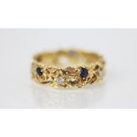 A diamond and sapphire set 18ct gold ring, the pierced floral design ring set with five round