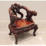 A Chinese carved hardwood dragon tub chair, early 20th century, the back formed from a pair of