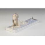 A Royal Copenhagen figure of a mermaid, designed by Christian Thomson, modelled lying in shallow