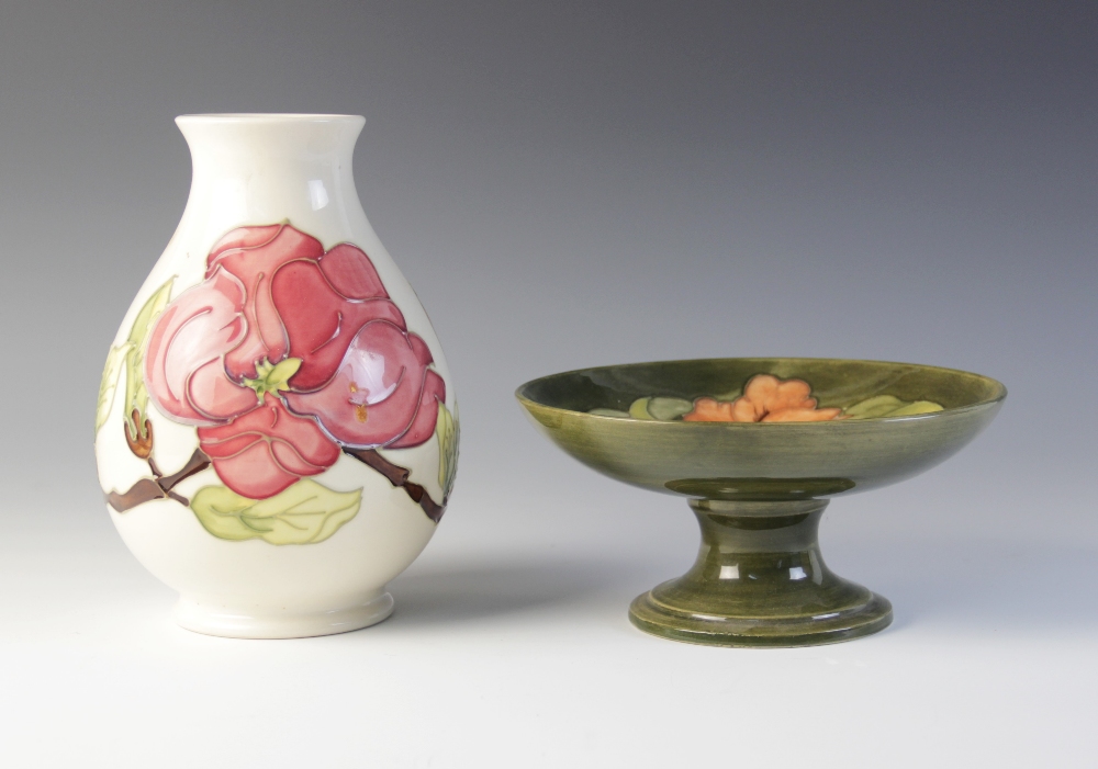 A Moorcroft compote decorated in the 'Hibiscus' pattern against a green ground, impressed maker's