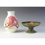 A Moorcroft compote decorated in the 'Hibiscus' pattern against a green ground, impressed maker's