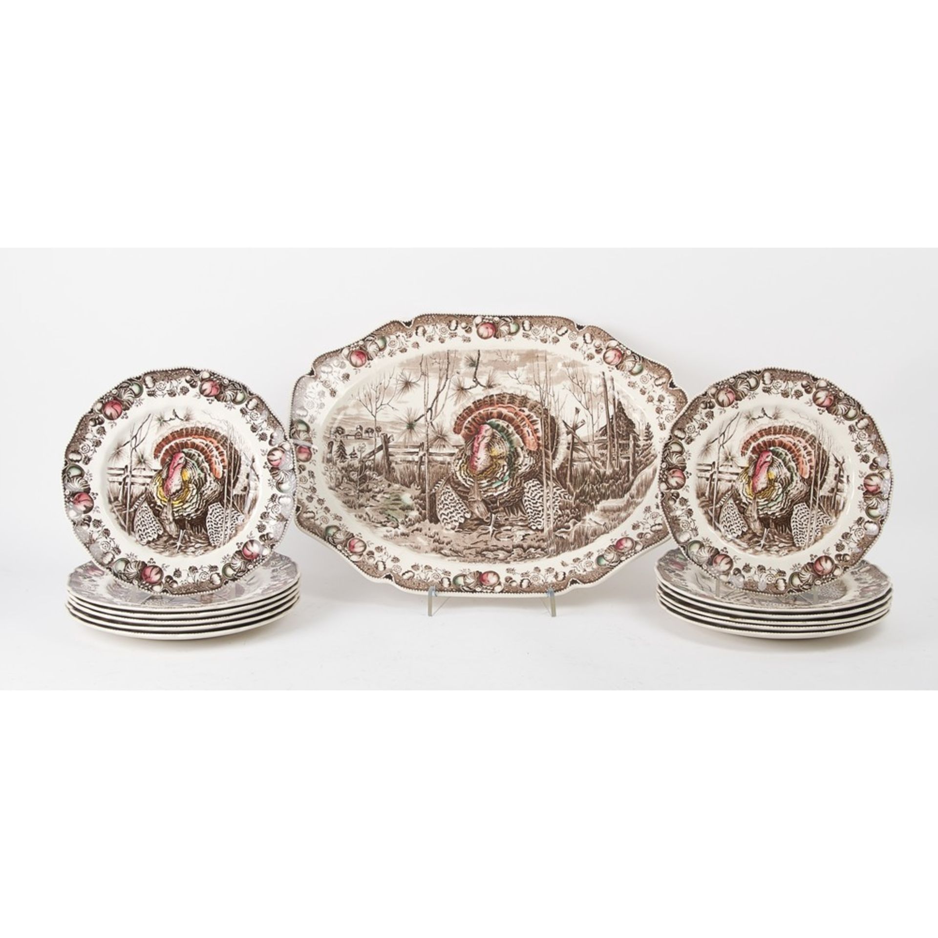 DODICI PIATTI e PIATTO da portata di forma sagomata in ceramica decorata a decalcomania raffigurante