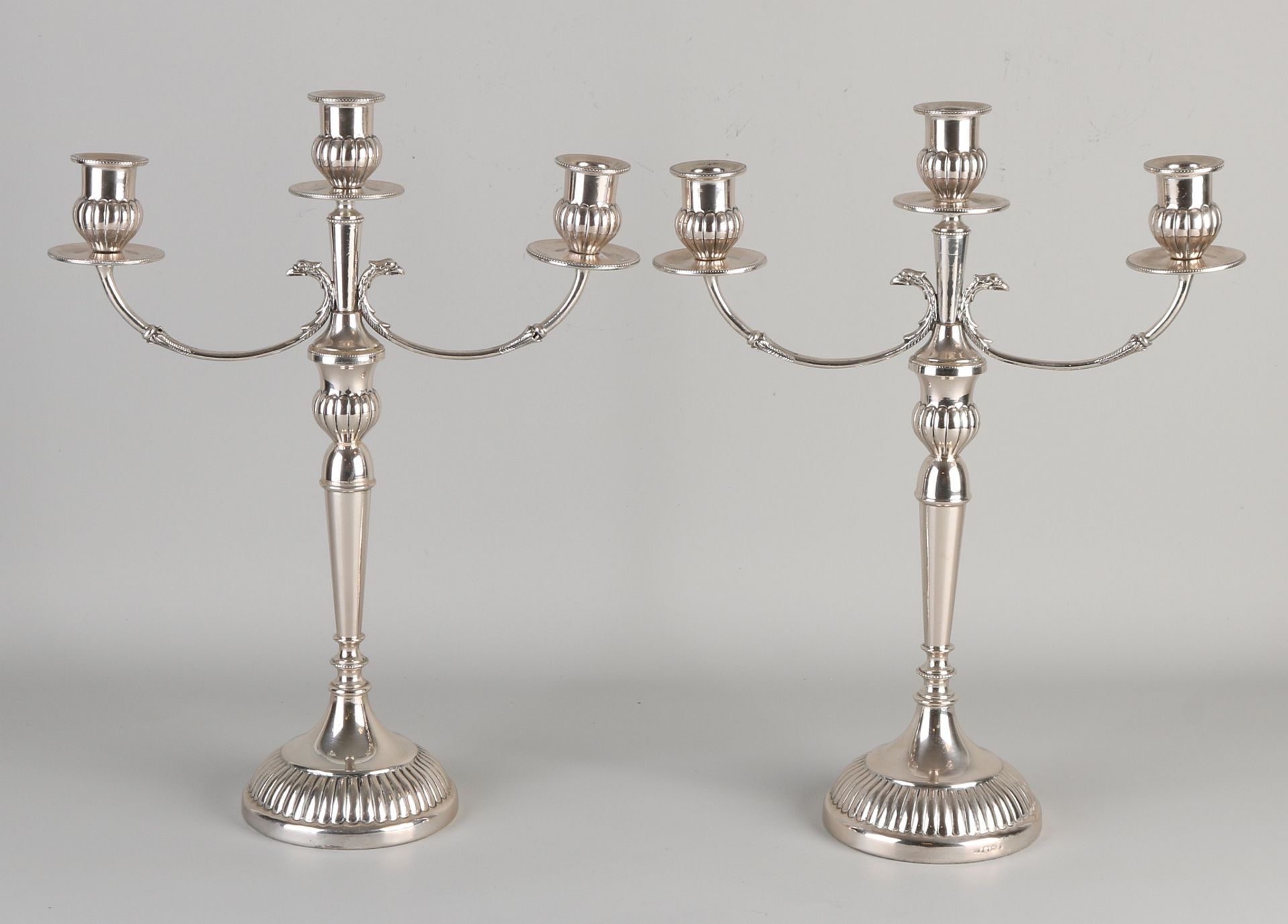 Paar silberne Kerzenhalter, 800/000, 3-Licht, auf einen runden Sockel gestellt und mit Adlerköpfen