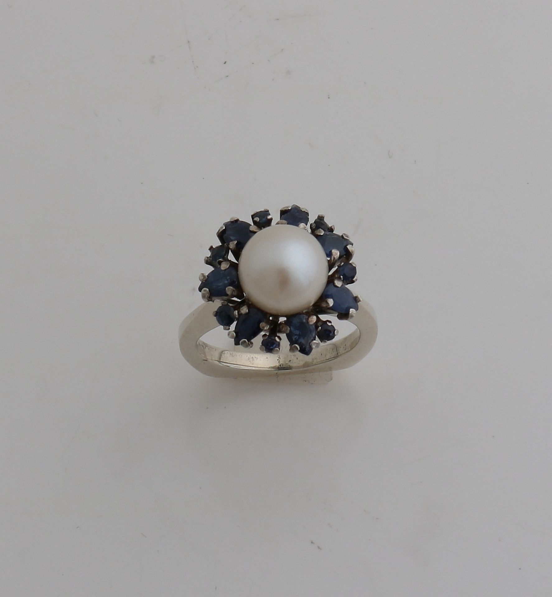 Weißgoldring, 585/000, mit Perle und Saphir. Ring mit einer Rosette in der Mitte mit einer Perle,