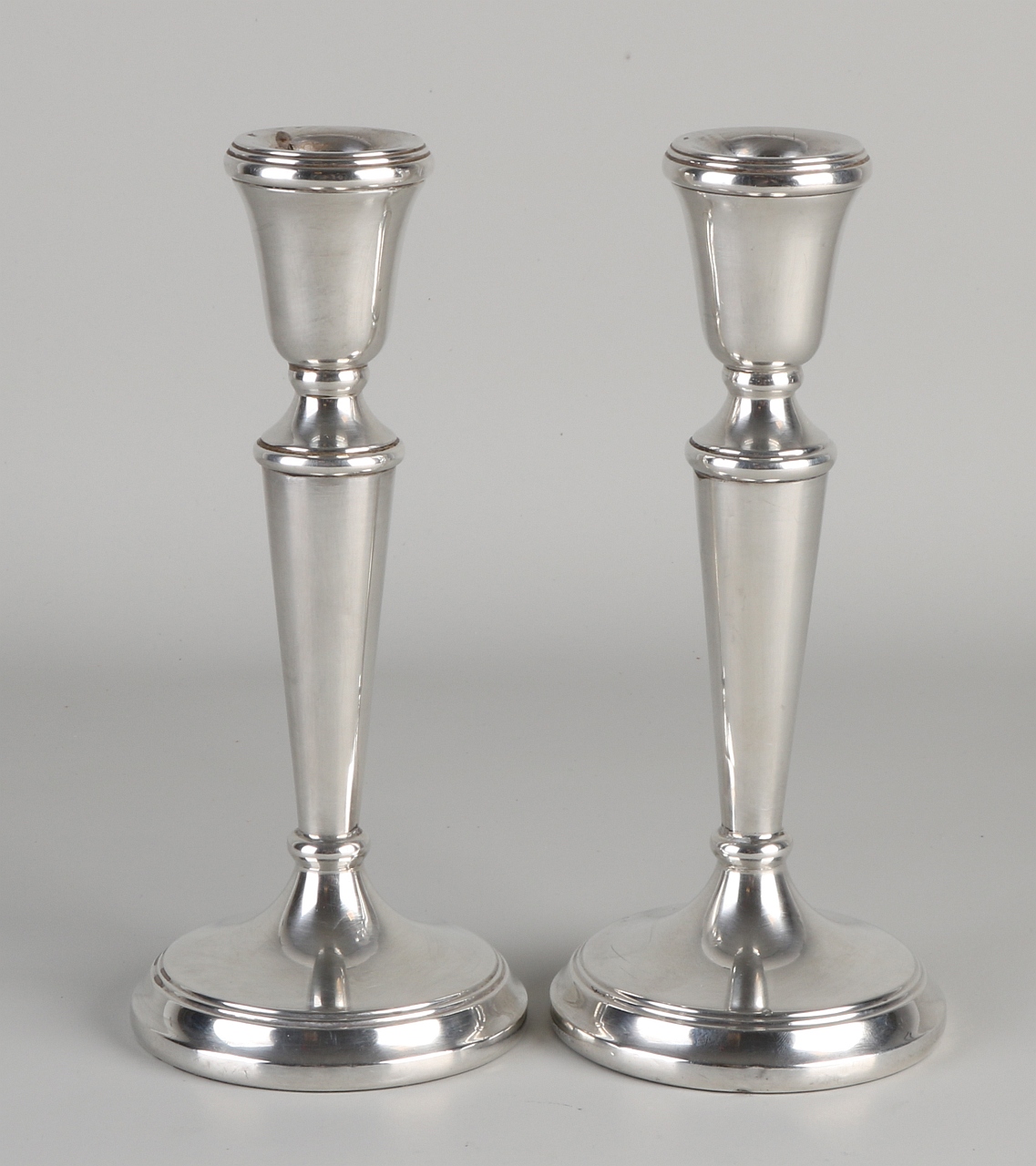 Zwei silberne Kerzenhalter, 925/000, auf rundem Boden mit Filetdekoration. Ein Kerzenhalter verbeu