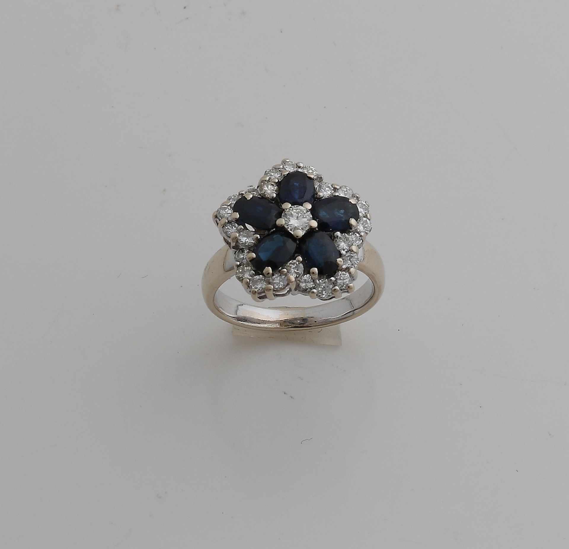 Eleganter Weißgoldring, 750/000, mit Diamant und Saphir. Ring mit einer blütenförmigen Rosette,