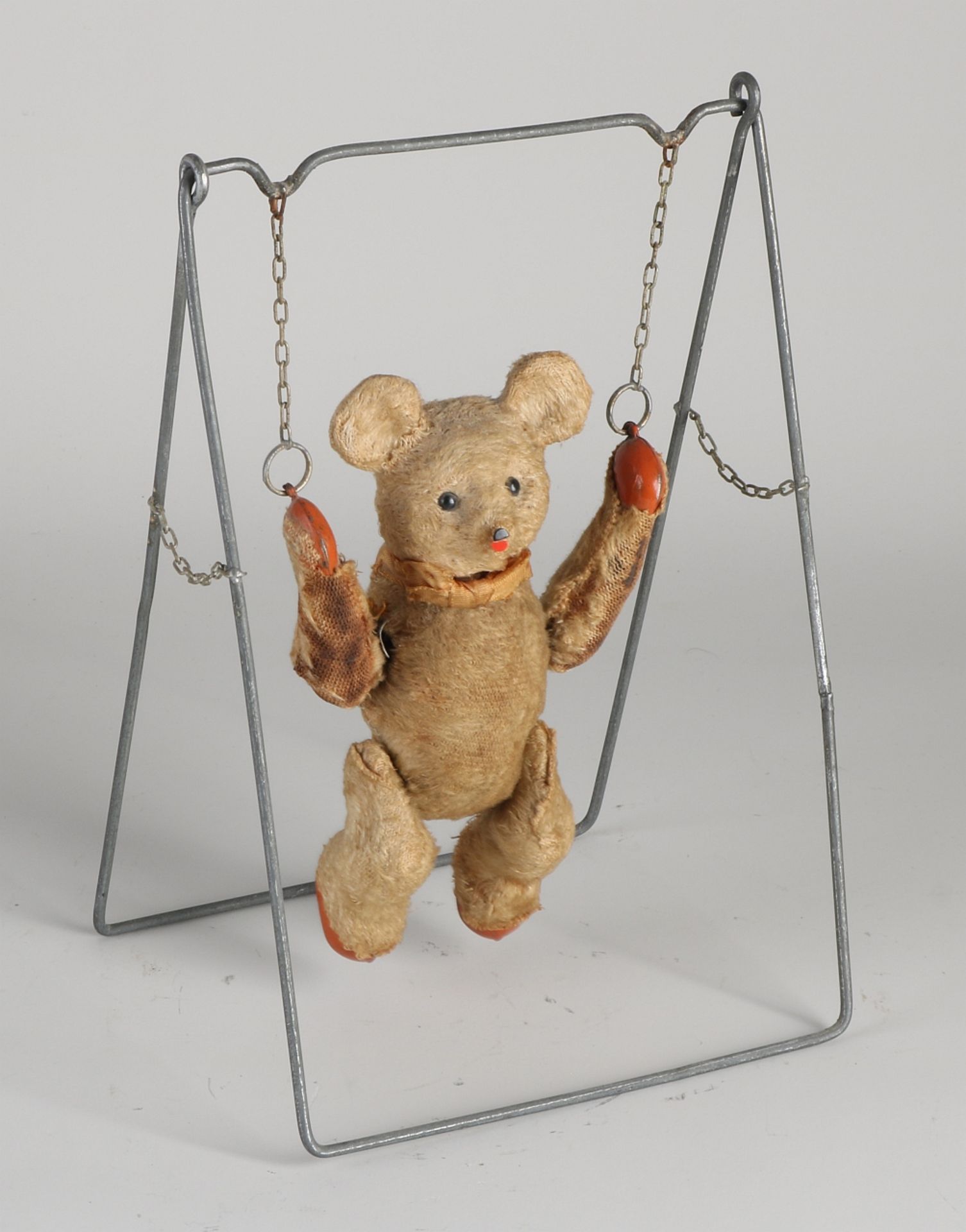 Antique teddy bear on swing, 1920