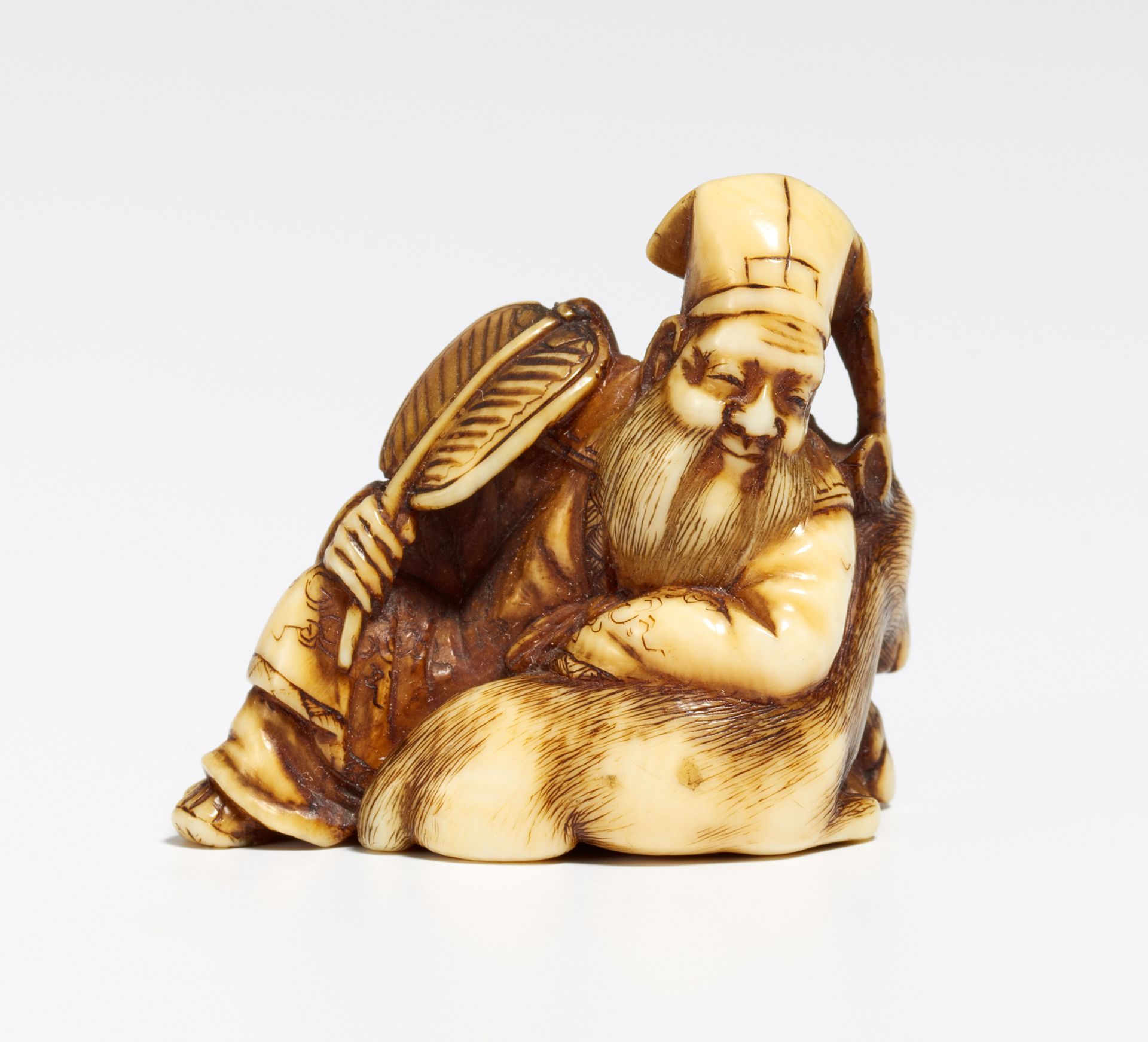 SMALL NETSUKE OF JURÔJIN WITH DEER. Japan. 19th c. Ivory, carved and engraved, partly stained black. - Bild 2 aus 2