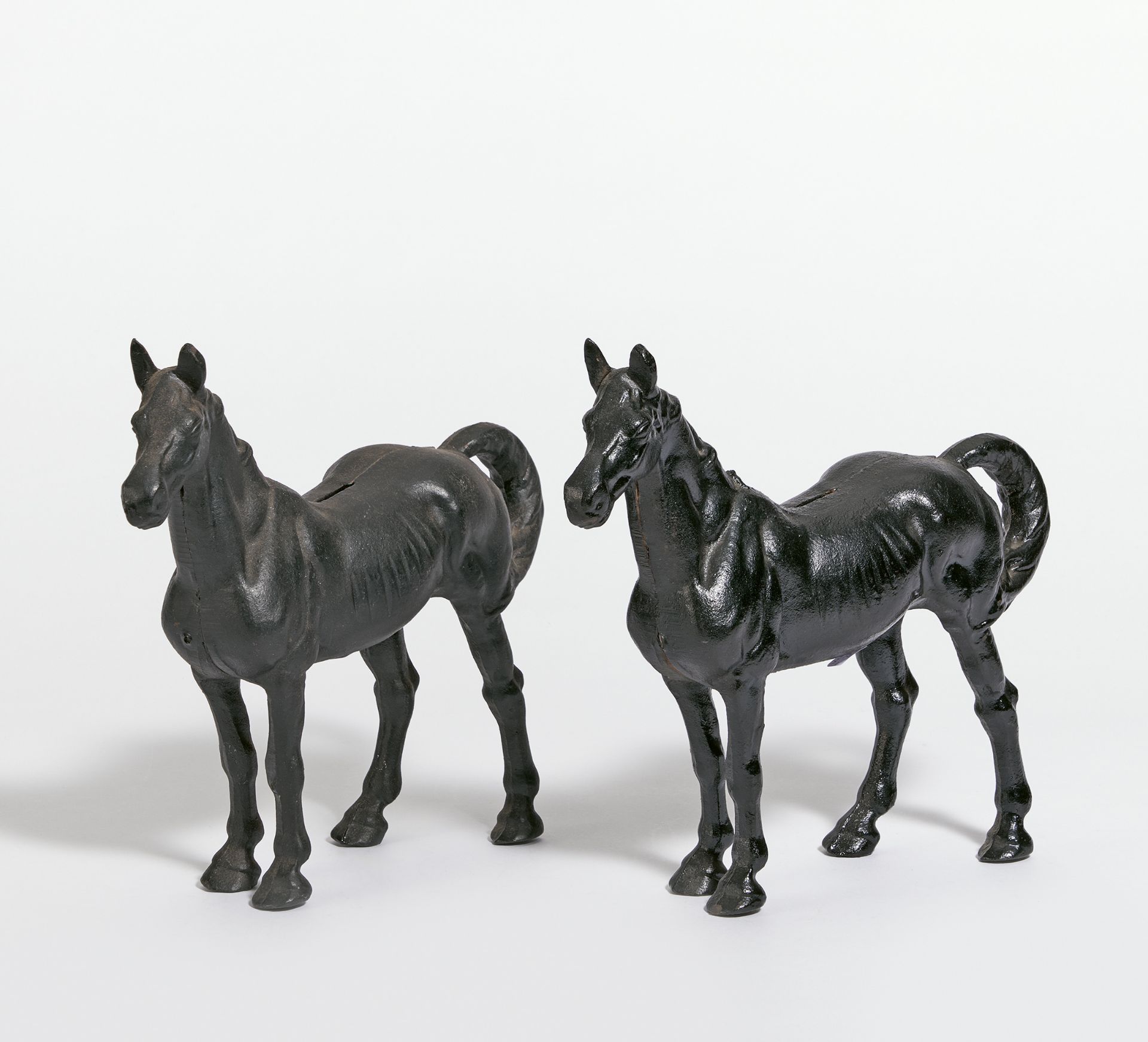 2 PFERDEFIGUREN ALS SPARDOSE. Metall, schwarz gefasst. H.24, L.27cm. Zustand B/C. Voraussichtliche