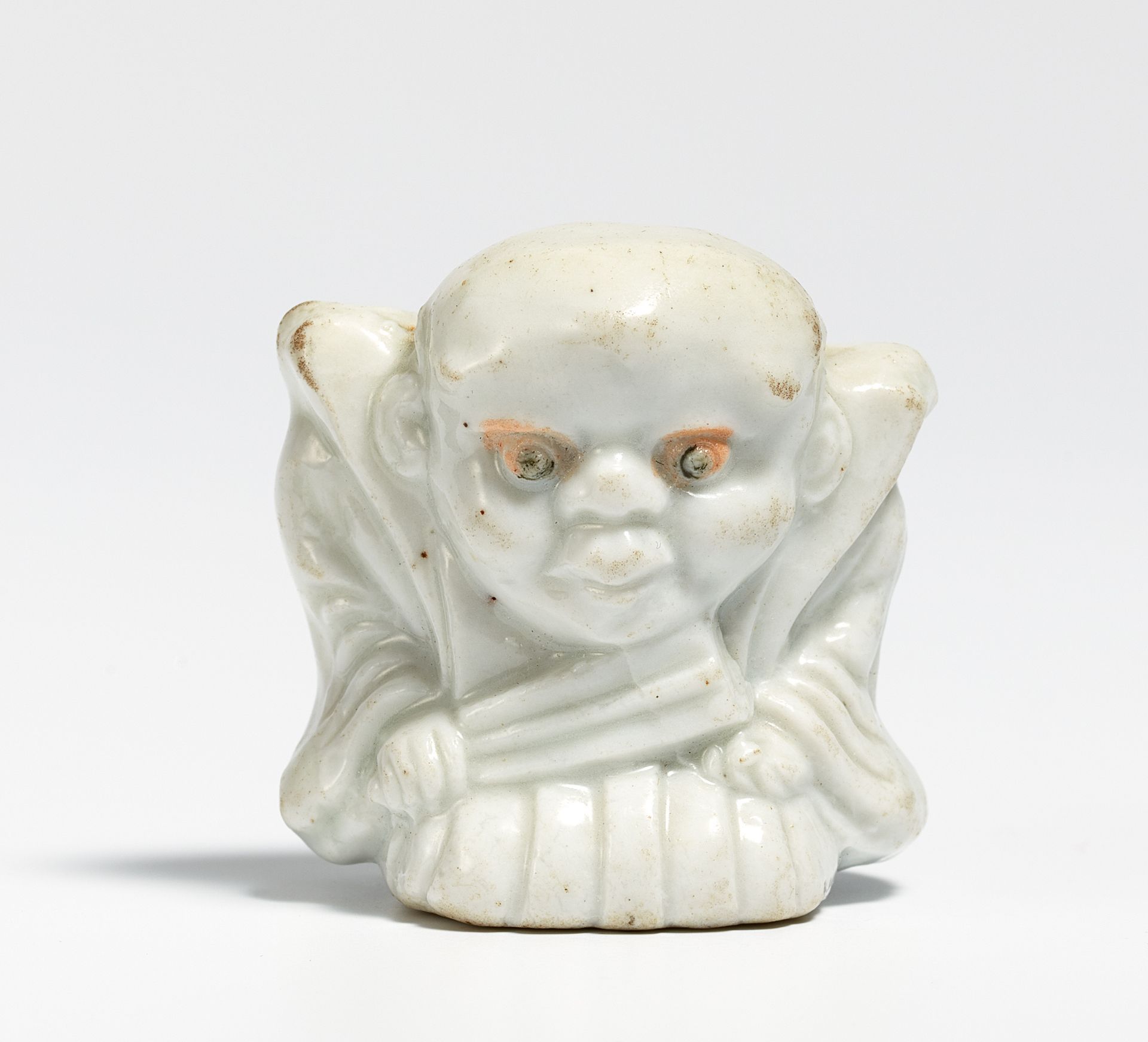 NETSUKE: THE LUCKY DWARF FUKUSUKE AS RAKUGO STORYTELLER. Japan. 19th c. Porcelain. H.3.7cm.