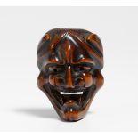 NETSUKE: HANNYA MASK. Japan. Mid 19th c. Wood, carved and partly dark colored. H.5.2cm. Condition