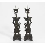 PAIR OF GUARDIANS AS CANDLESTICK. China. 18th-19th c. Bronze with dark patina. Each standing on a