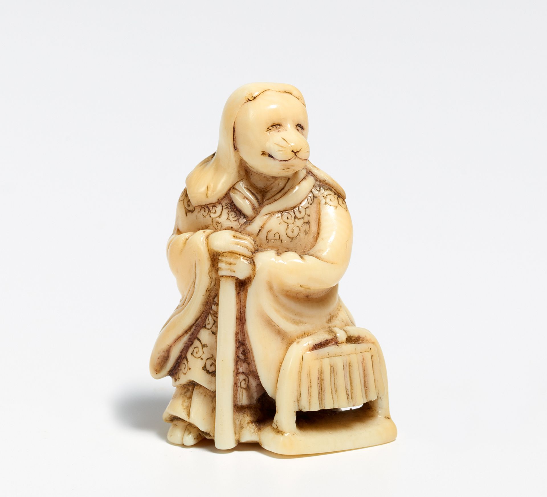 NETSUKE: TANUKI AS PRIEST WITH BIRD SCARER. Japan. 19th c. Ivory, carved with fine engraving. - Bild 2 aus 2