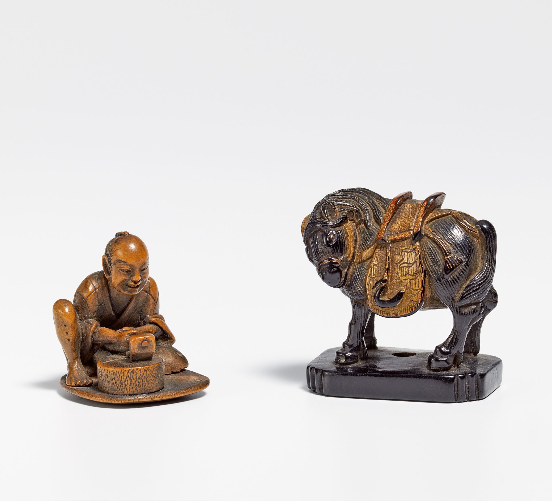 ZWEI NETSUKE: STONE MASON AND HORSE. Japan. 19th c. Wood, carved, at the horse black, red and gold