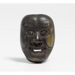 NETSUKE: OJI MASK. Japan. 19th-20th c. Black ceramic with a little bit of glaze. Maker seal