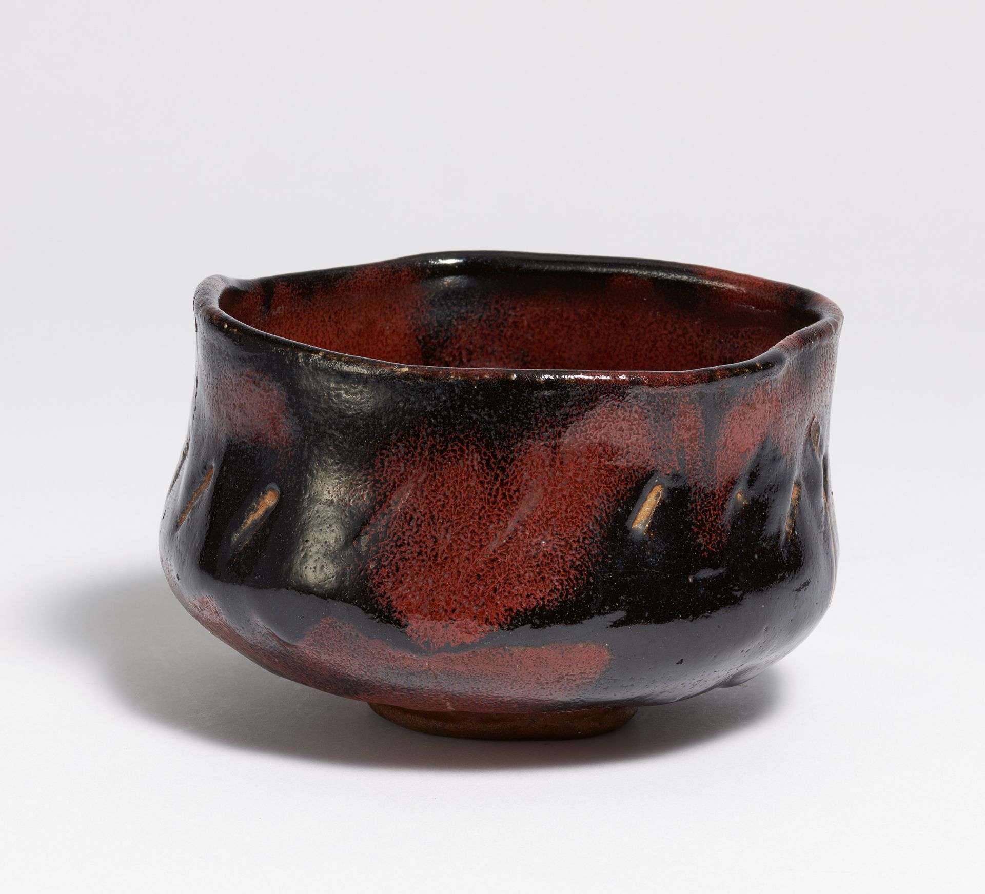 LARGE TEA BOWL (CHAWAN) IN RED BLACK RAKU. Japan. 19th c. Brownish stoneware with chamotte with