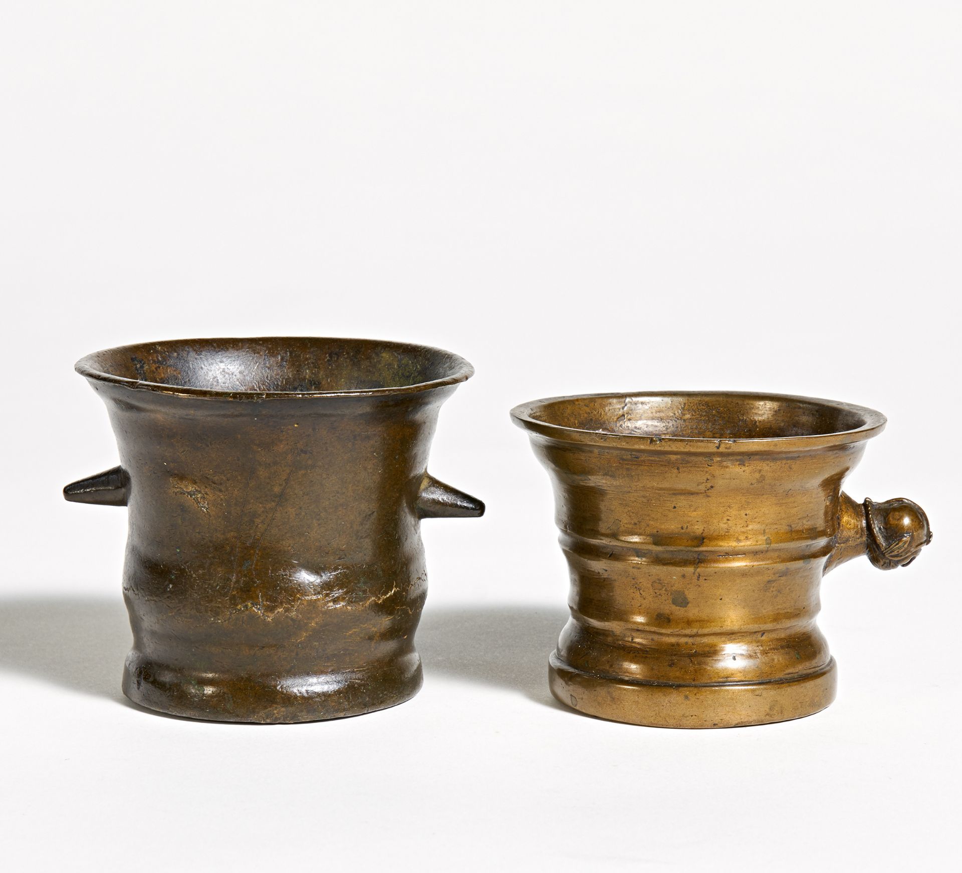 KLEINER MÖRSER MIT MASKENGRIFF UND KLEINER GLOCKENMÖRSER. Bronze. H.8/6,5cm, ø9/8,5cm. Zustand B.